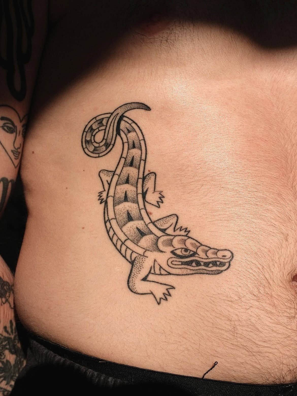 Tatouage handpoke d'un alligator sur le flanc