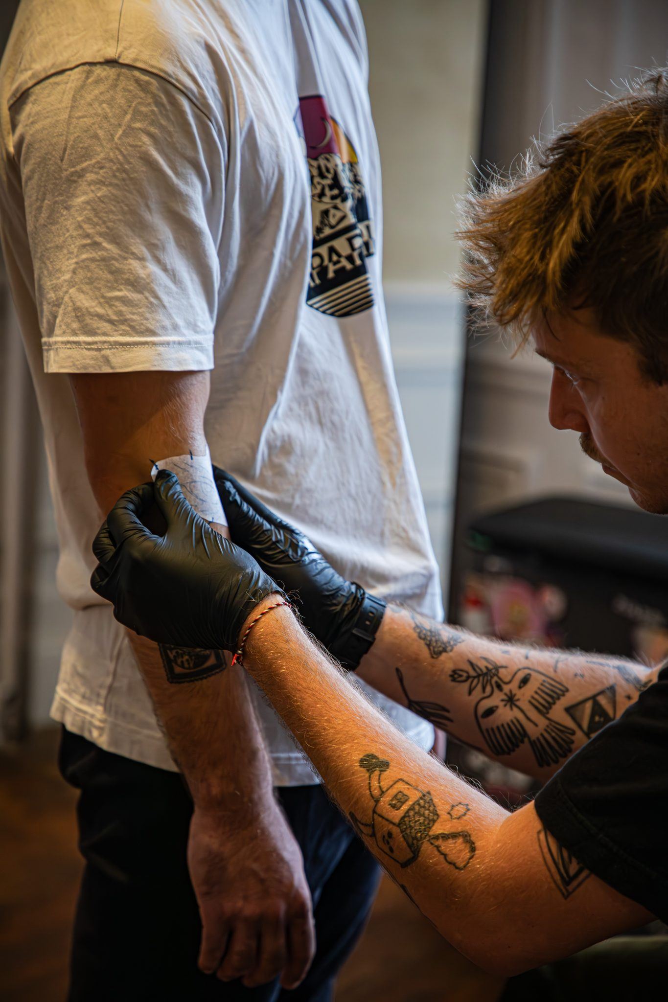 Piga en train de tatouer un bras à la main