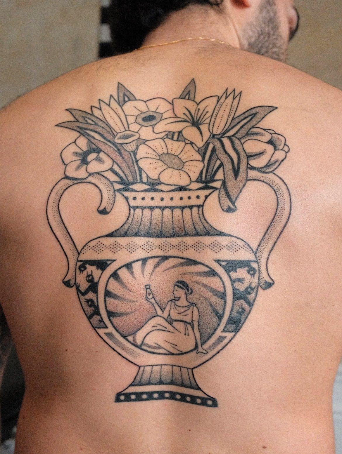 Grand tatouage handpoke d'un vase fleuri sur le dos