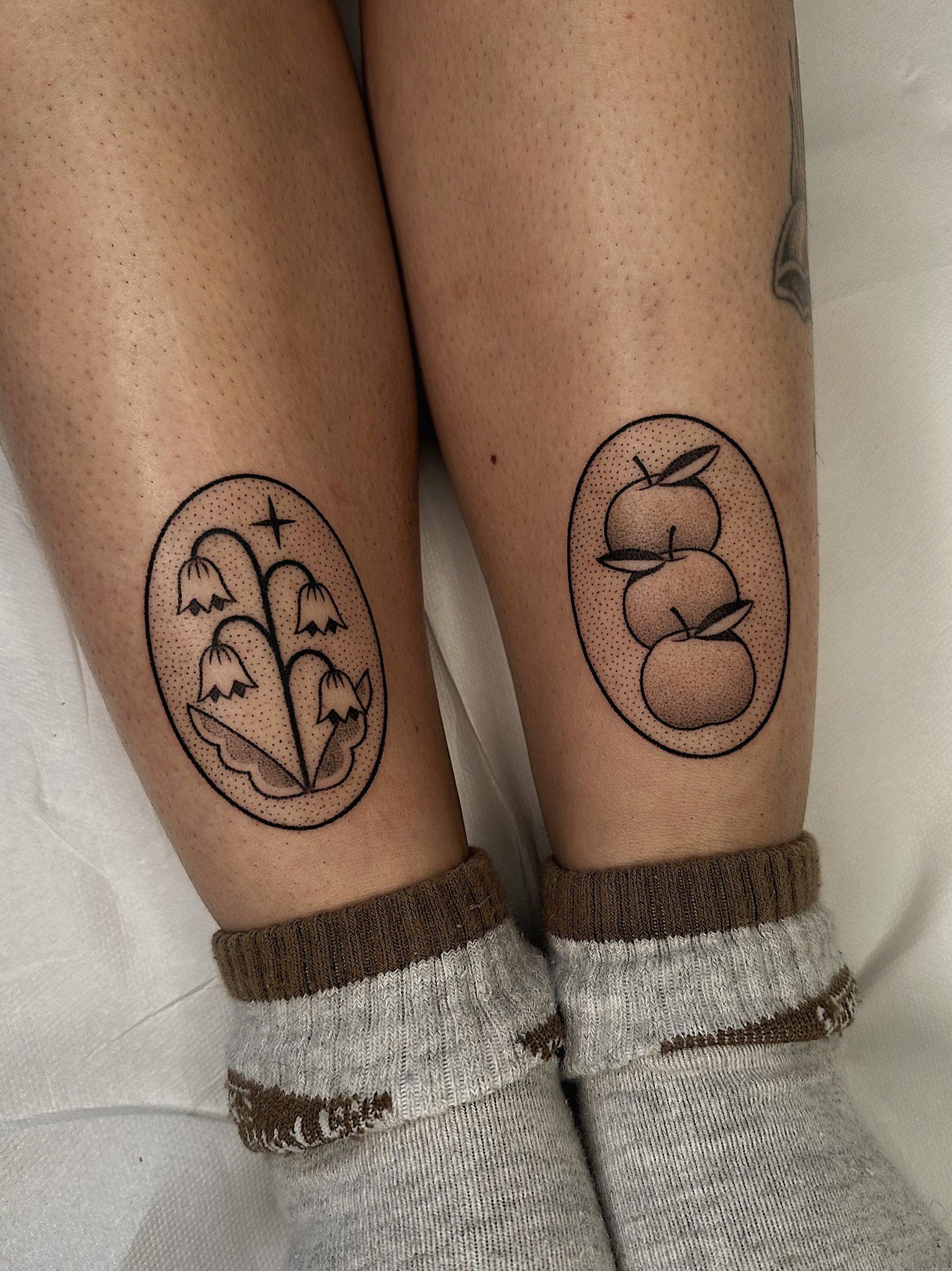 Deux tatouages handpoke en médaillon sur les mollets